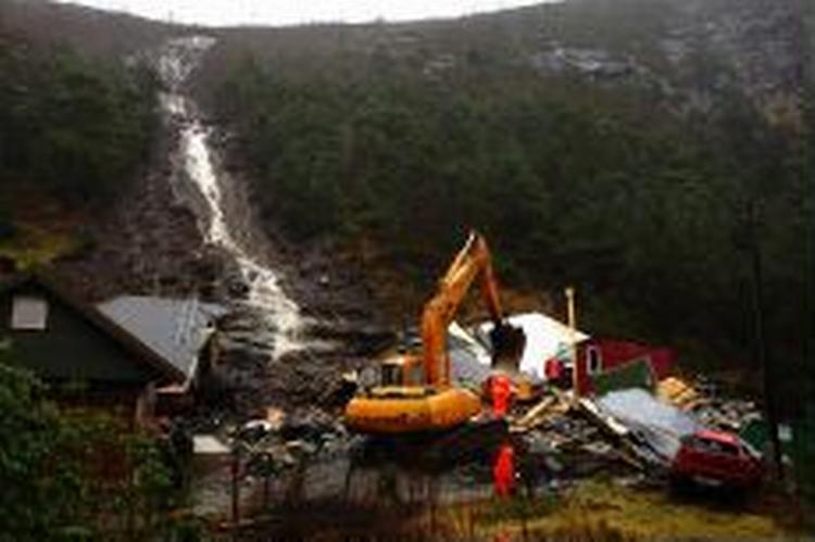 Uvejret i Norge var årsag til et utal af jordskred. Her er et hus ved Bergen bliver skubbet væk af jord og vand. - Foto: AP 