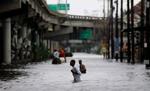 Borgere i New Orleans går i vand til livet efter orkanen Katrina 29. august oversvømmede byen. Der er stadig 321 lig, der ikke er identificeret. - Arkivfoto: AP 