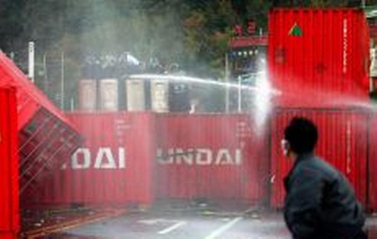 Der er sammenstød mellem politi med vandkanoner og stenkastende aktivister ved APEC-topmødet i Pusan i Sydkorea. - Foto: AP 