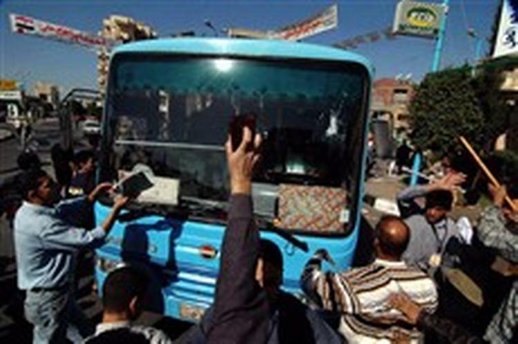 Medlemmer af Broderskabet omringer en bus med tilhængere af regeringspartiet NDP i Dananhur nord for Kairo. De blev på stedet anklaget for valgfusk.   Foto: Nasser Nouri/AP 