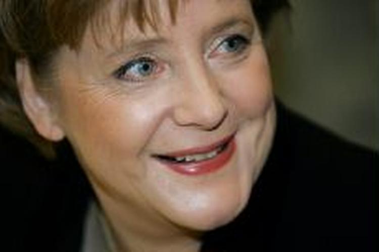 Angela Merkel smiler ved et møde i parlamentet, umiddelbart, før hun officielt blev nævnt. - Foto: AP 