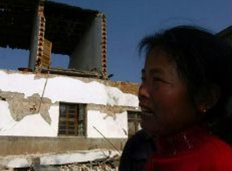 En kvinde leder efter sin datter i ruinerne i byen Xixinqiao. - Foto: AP 