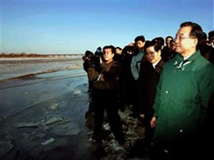 Kinas ministerpræsident Wen Jiabao (th.) ved bredden af den forurenede flod.   Foto: Yao Dawei/AP 