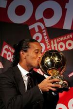 Den brasilianske boldkunstner Ronaldinho kysser trofæet, Den Gyldne Bold, der er beviset på, at han er tildelt æren som den bedste fodboldspiller i Europa. - Foto: AP 
