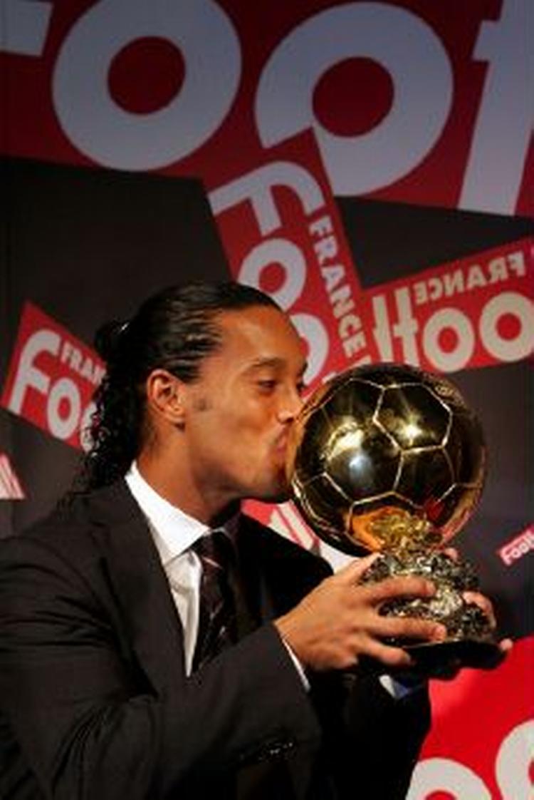 Den brasilianske boldkunstner Ronaldinho kysser trofæet, Den Gyldne Bold, der er beviset på, at han er tildelt æren som den bedste fodboldspiller i Europa. - Foto: AP 