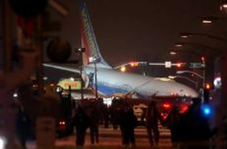 Et fly skred af landingsbanen i Chicago og pløjede sig vej ind i trafikken omkring lufthavnen, hvor en dreng blev dræbt. - Foto: AP 