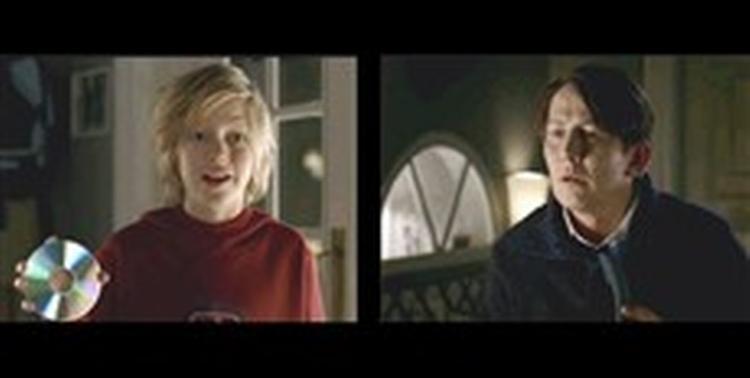 . Thomas Bo Larsen forsøger at huske en melodi, han har på hjernen. Gudskelov er hjælpen nær   sønnen downloader nummeret fra nettet og brænder det på en cd.   Foto fra TDC s tv-spot 