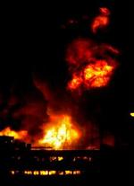 Flammer stiger til morgen op fra oliedepotet Buncefield nær London. - Foto: AP 