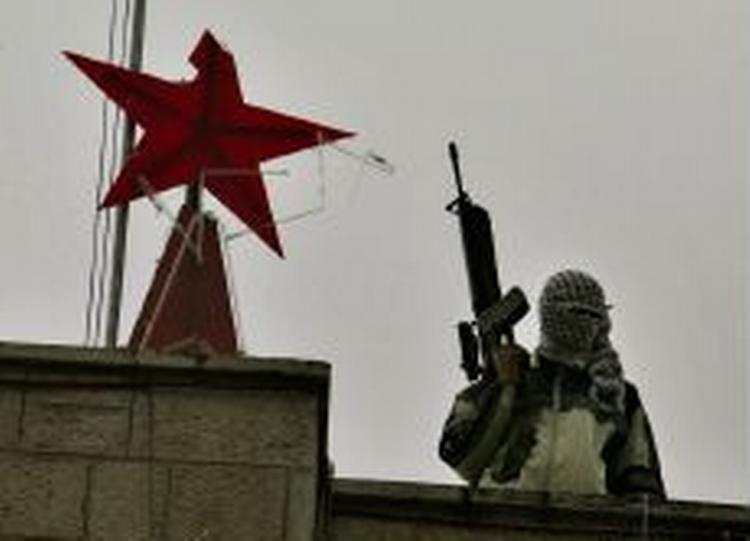 En maskeret militant palæstinenser på taget af rådhuset under den kortvarige besættelse. - Foto: AP 