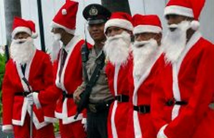 Indonesiske vagtmænd er klædt ud som Julemænd i anledning af højtiden. - Foto: AP 
