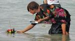 En uidentificeret kvinde sætter et lys i havet under en mindehøjtidelighed i Thailand. - Foto: AP 