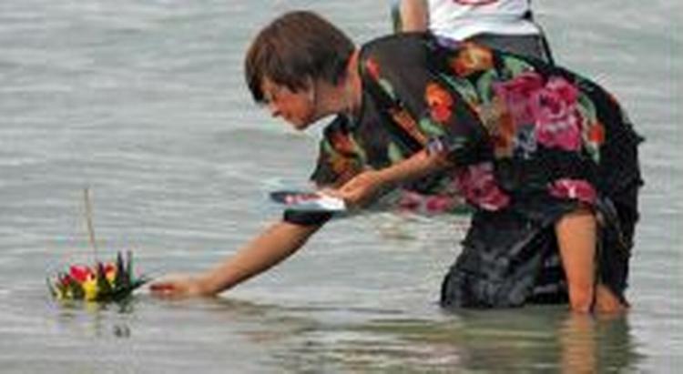 En uidentificeret kvinde sætter et lys i havet under en mindehøjtidelighed i Thailand. - Foto: AP 
