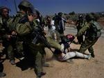 Bilin har længe været omstridt, fordi fredsaktivister forsøger at standse byggeriet af sikkerhedsbarrieren. Her sparker en israelsk soldat en demonstrant.   Arkivfoto: Nasser Nasser/AP 