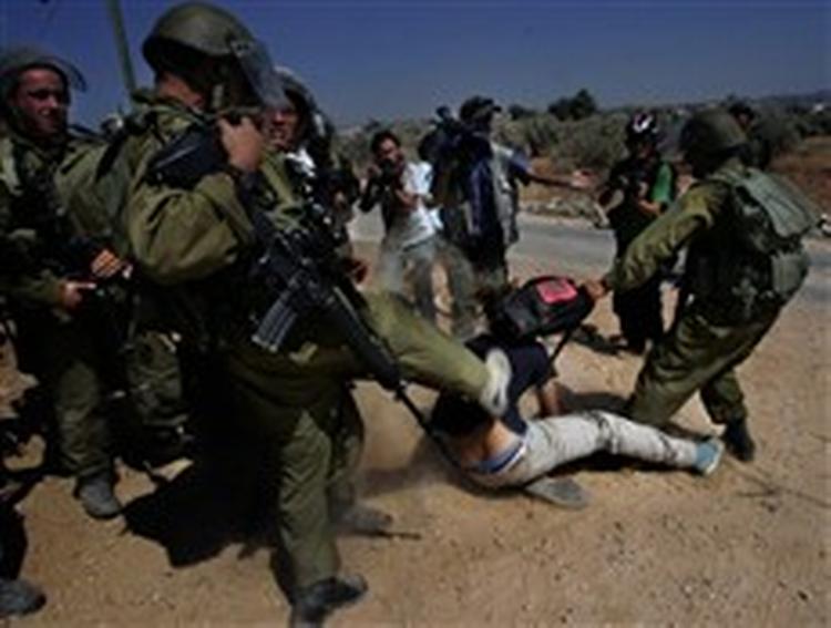 Bilin har længe været omstridt, fordi fredsaktivister forsøger at standse byggeriet af sikkerhedsbarrieren. Her sparker en israelsk soldat en demonstrant.   Arkivfoto: Nasser Nasser/AP 