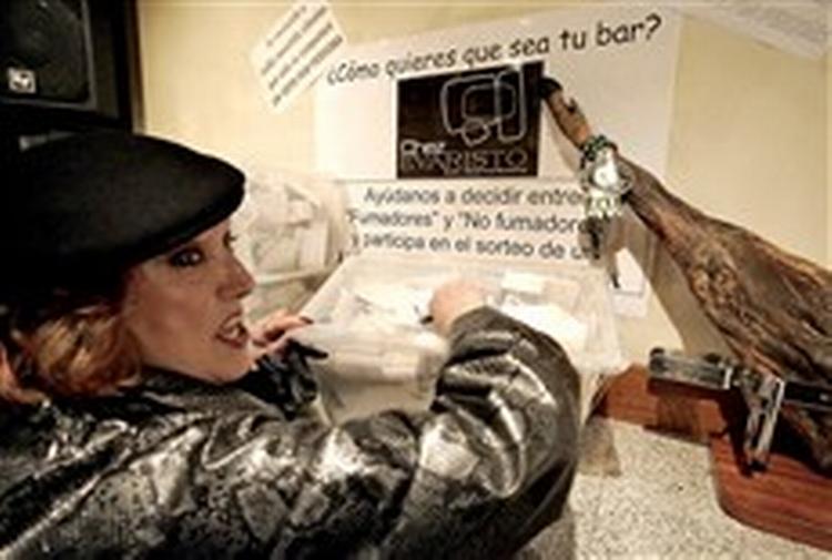 En bargæst i Pamplona i Nordspanien afgiver sin stemme, så ejeren ved, hvordan publikum vil have det: røg eller ej?   Foto: Alvaro Barrientos/AP 