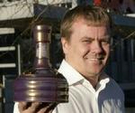 Coops kategorichef Kenn Thomsen viser en flaske af Danmarks hidtil dyreste øl, 'Samuel Adams Utopias 2005'. - Foto: Coop 