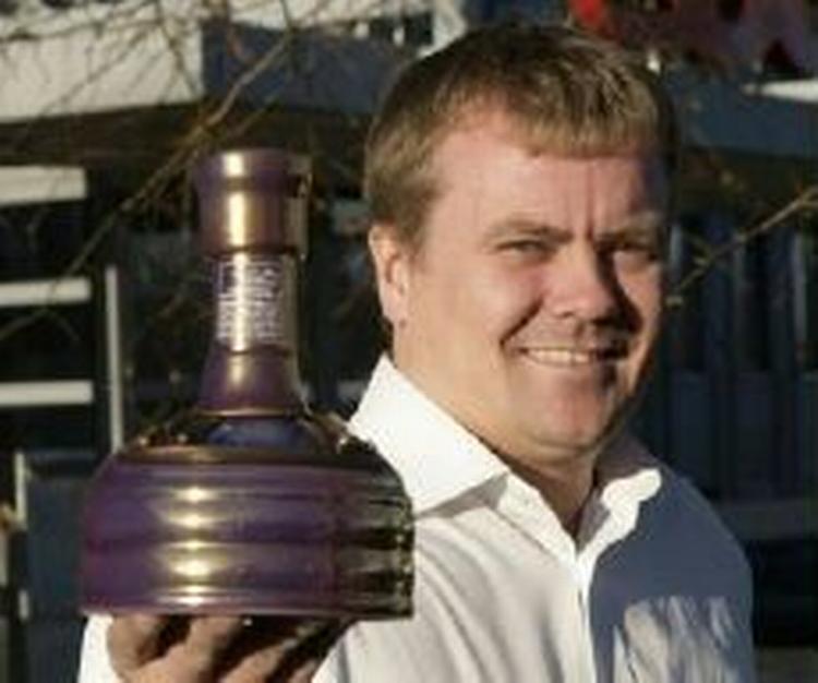 Coops kategorichef Kenn Thomsen viser en flaske af Danmarks hidtil dyreste øl, 'Samuel Adams Utopias 2005'. - Foto: Coop 