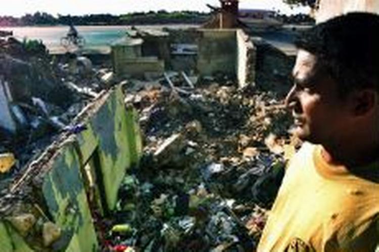 28. januar 2005: I Sri Lanka betragter en mand resterne af sit og familiens hjem, der blev taget af tsunamien. - Foto: AP 