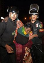 Egyptisk politi stormede i dag telte med sudanesiske flygtninge i Cairo. Her bæres en såret flygtning væk af politi. - Foto: AP 