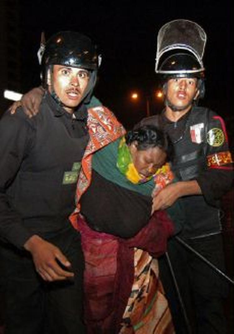 Egyptisk politi stormede i dag telte med sudanesiske flygtninge i Cairo. Her bæres en såret flygtning væk af politi. - Foto: AP 