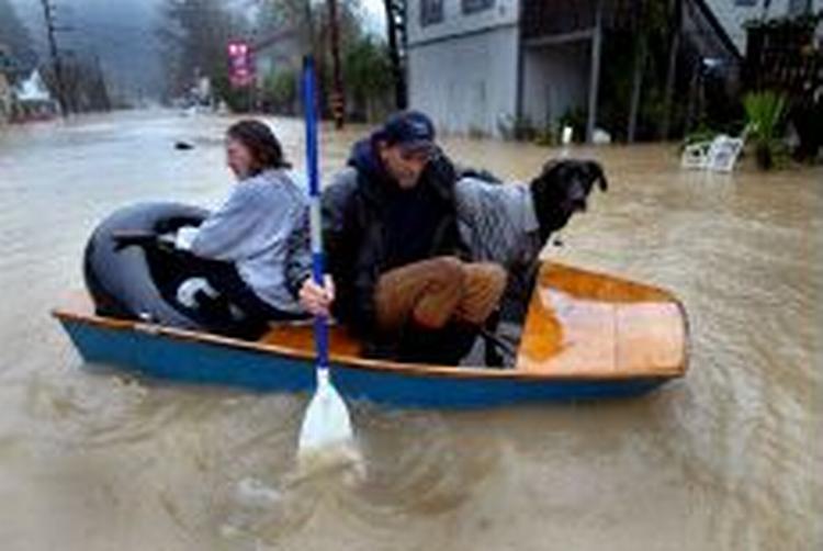 Beboerne i Guerneville i Californien kommer rundt i byen med kano. Men stormen og regnen er nu på vej mod syd. - Foto: AP 