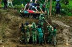 Indonesiske redningsfolk hjælper en ældre kvinde ved Panti i den østlige del af Java efter det voldsomme uvejr, som har forårsaget jordskred og isolation af landsbyer. - Foto: AP 