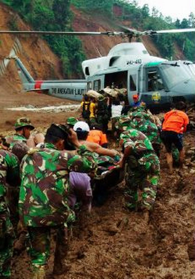 Indonesiske soldater og redningsarbejdere har travlt med at bjærge ligene, der ligger begravet i mudder. - Foto: AP 