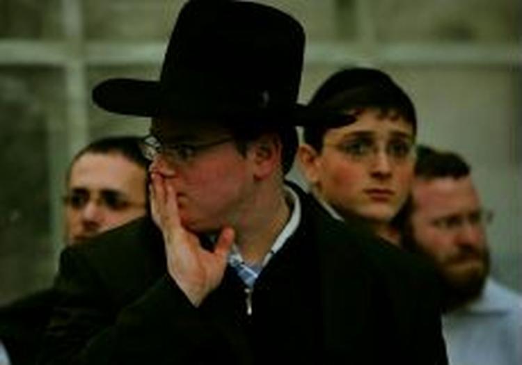 Pressefolk, vagter og nysgerrige borgere - som denne ortodoske jøde - samles uden for Hadassah-hospitalet i Jerusalem, hvor Sharon er indlagt. - Foto: AP 
