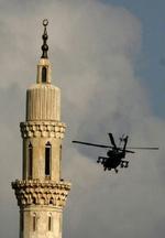 En amerikansk militærhelikopter hjælper med overvågningen af Indenrigsministeriet i Irak, hvor to forklædte bombemænd havde held med et attentat i dag. - Foto: AP 