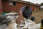 Ellis Brent fra et af de hårdest ramte områder efter Katrina, Lower Ninth Ward, renser sine CD'er der blev ødelagt under orkanen. - Foto: AP 