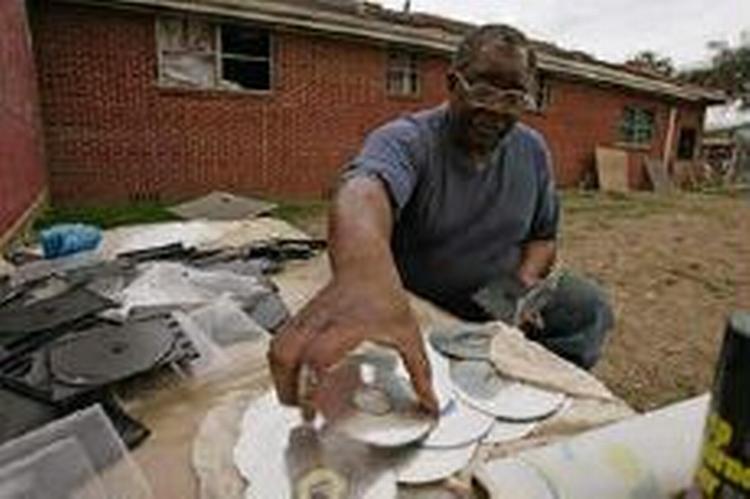 Ellis Brent fra et af de hårdest ramte områder efter Katrina, Lower Ninth Ward, renser sine CD'er der blev ødelagt under orkanen. - Foto: AP 