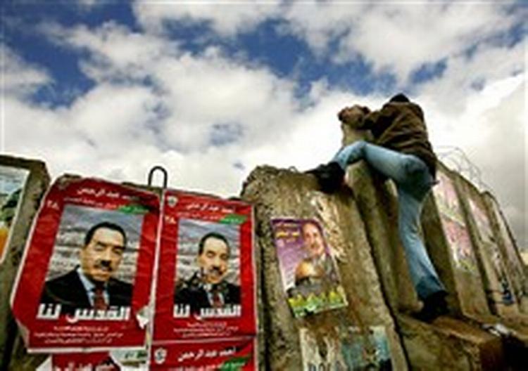 En del af den israelske sikkerhedsmur mellem palæstinensiske og israelske områder bruges i valgkampen i Østjerusalem   til at sætte plakater op på.   Foto: Emilio Morenatti/AP 