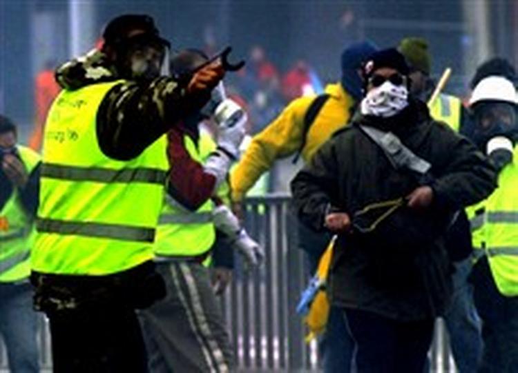 Samme dag som 35.000 europæiske havnearbejdere lod kranerne stå i protest, indledte de en voldsom demonstration foran EU-Parlamentet i Strasbourg. Politiet måtte bruge tåregas og vandkanoner for at holde de vrede demonstranter tilbage. - Foto: AP 
