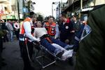 Sårede får hjælp efter bombeangrebet i Tel Aviv. - Foto: AP 