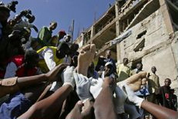 Redningsfolk bærer en overlevende ud af den sammenstyrtede bygning i midten af Nairobi. Mere end 200 frygtes indespærret. - Foto: AP 