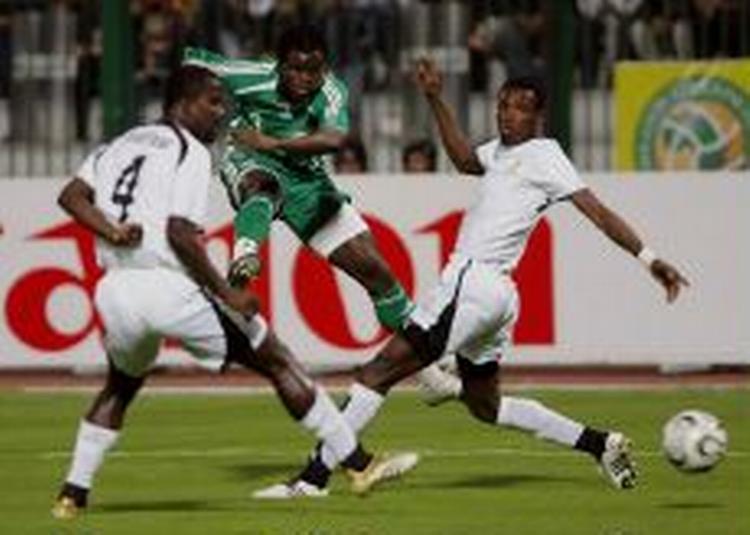 Matchvinder Taiwo fyrer kanonen af mellem to ghanesere. - Foto: AP 