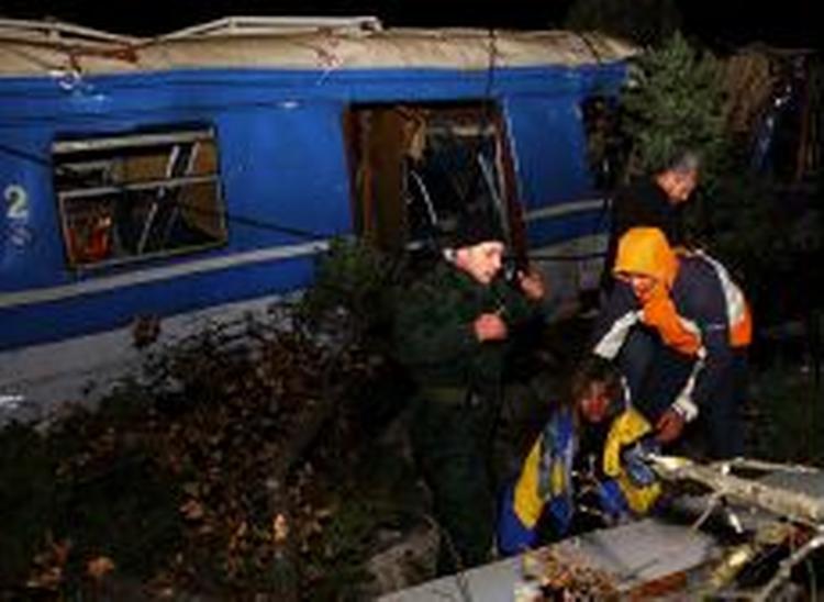 Redningsfolk ser efter en af de sårede efter togafsporingen nord for den montenegrinske hovedstad. - Foto: AP 