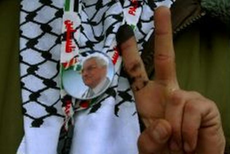 En palæstinensisk vælger på Vestbredden viser sejrtegnet efter at have stemt på den nuværende leder Mahmoud Abbas ved dagens valg. - Foto: AP 