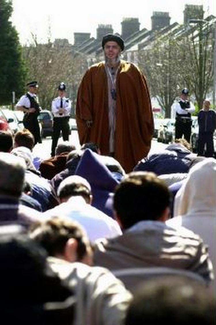 Den radikale muslimske præst Abu Hamza al-Masri prædiker foran muslimer på en gade i London. Han er nu idømt syv års fængsel. - Foto: AP 