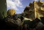 Amerikanske soldater undersøger tage i Ramadi, Irak for snigskytter. Omkring 55 milliarder kroner, der skulle have været brugt til landets genopbygning, er forsvundet. - Foto: AP 