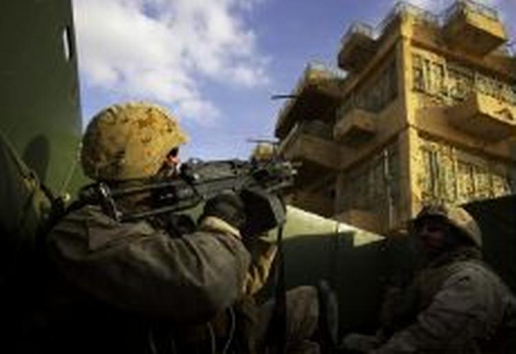 Amerikanske soldater undersøger tage i Ramadi, Irak for snigskytter. Omkring 55 milliarder kroner, der skulle have været brugt til landets genopbygning, er forsvundet. - Foto: AP 