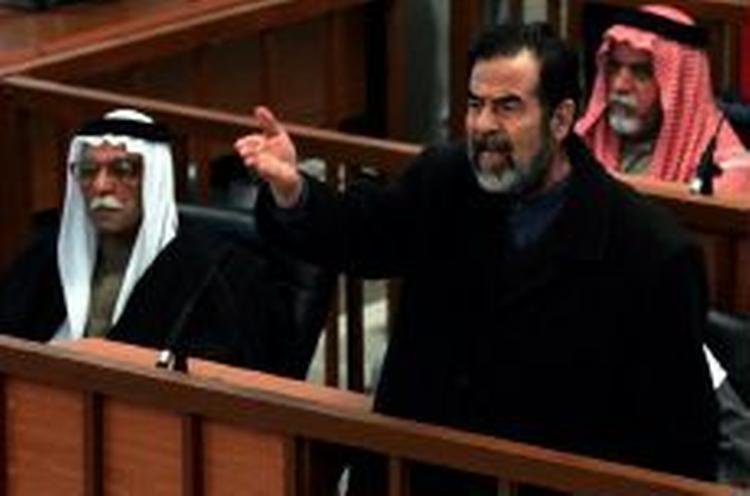 »Ned med forræderen, ned med forræderne, ned med Bush..., længe leve ummah en (den islamiske nation)..., længe leve ummah en..., længe leve ummah en...«, råbte Saddam da han trådte ind i retten. - Foto: AP 
