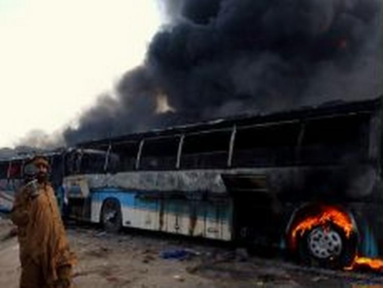 Vrede menneskemængder er på gaden for tredje dag i træk i Pakistan i protest over Jyllands-Postens Muhammed-tegninger. Her ses en brændende bus i Peshawar. - Foto: AP 
