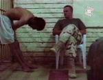 En irakisk fange bøjer sig for en amerikansk soldat i Abu Ghraib-fængslet. - Foto: AP 