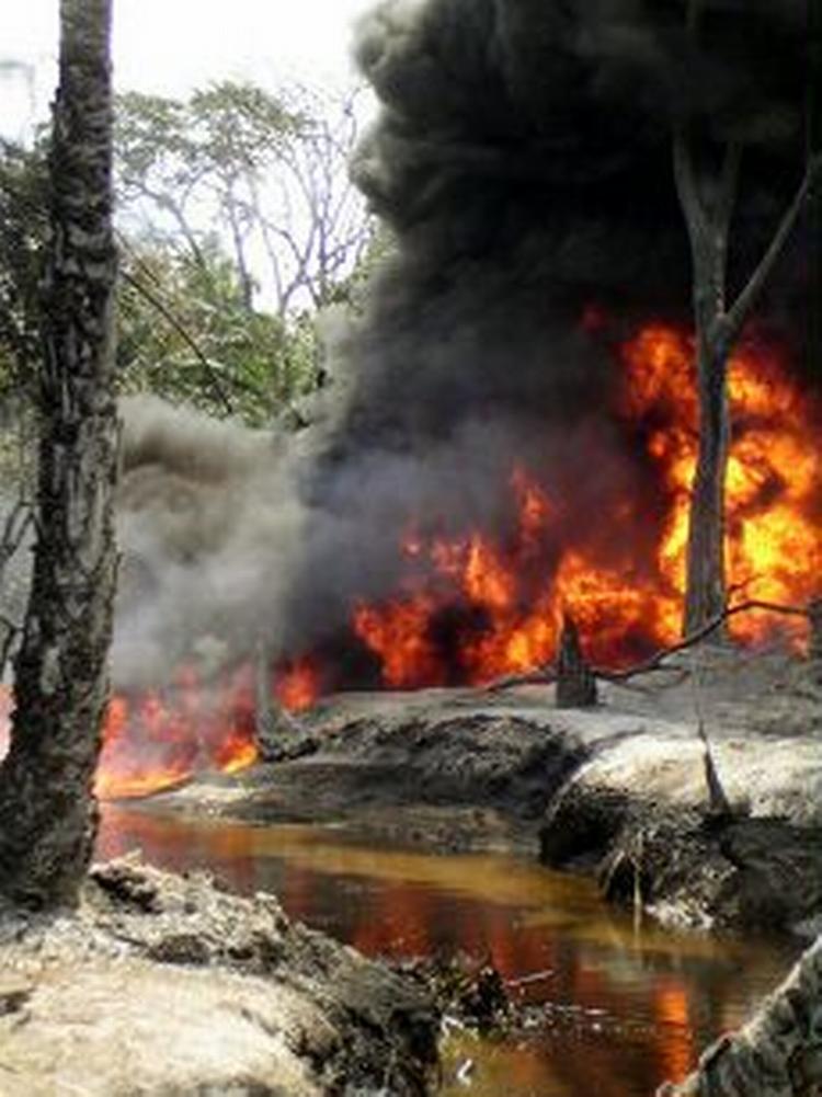 En lækage i en olieledning brænder i Nigeria i oktober 2004. Shells boringer og udslippet derfra har ødelagt miljøet i visse områder af Nigeria. Nu skal Shell kompensere de oprindelige indbyggere i området. - Arkivfoto: AP 