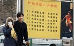 Et kinesisk par går forbi en liste over 'gadeadfærd', der ikke længere tillades i Beijing. Spytteriet er det første, der bliver gjort op med. - Foto: AP 