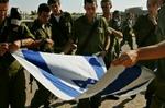Israelske soldater folder det israelske flag sammen som en del af forberedelserne, da de sidste år trak sig tilbage fra Gaza. - Arkivfoto: AP 