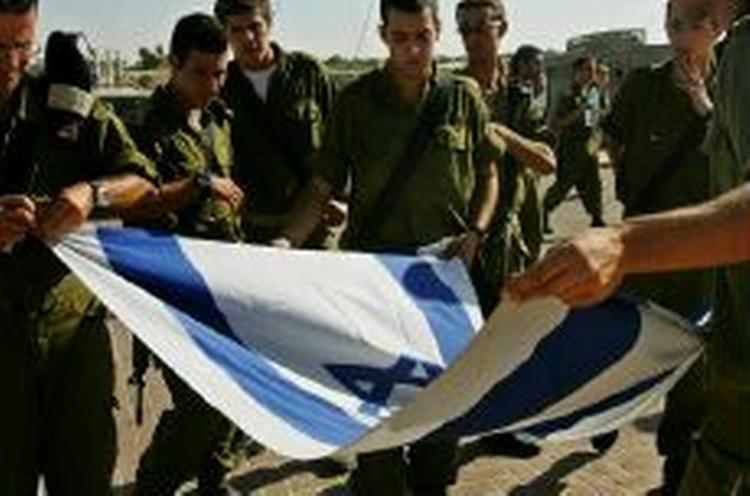 Israelske soldater folder det israelske flag sammen som en del af forberedelserne, da de sidste år trak sig tilbage fra Gaza. - Arkivfoto: AP 