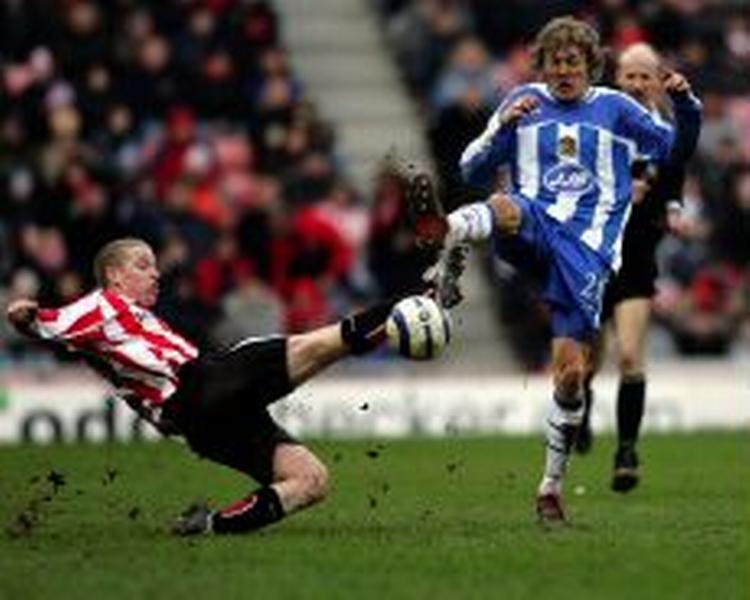 Sunderlands Leadbitter takler Wigans Bullard i opgøret i det nordengelske, som Wigan vandt. - Foto: AP 