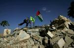 Tre vestlige gidsler er frigivet i Gaza. Imens ventes demonstrationer efter israelernes belejring af fængslet i Jeriko, hvor en palæstinenser her sætter et flag op. - Foto: AP 